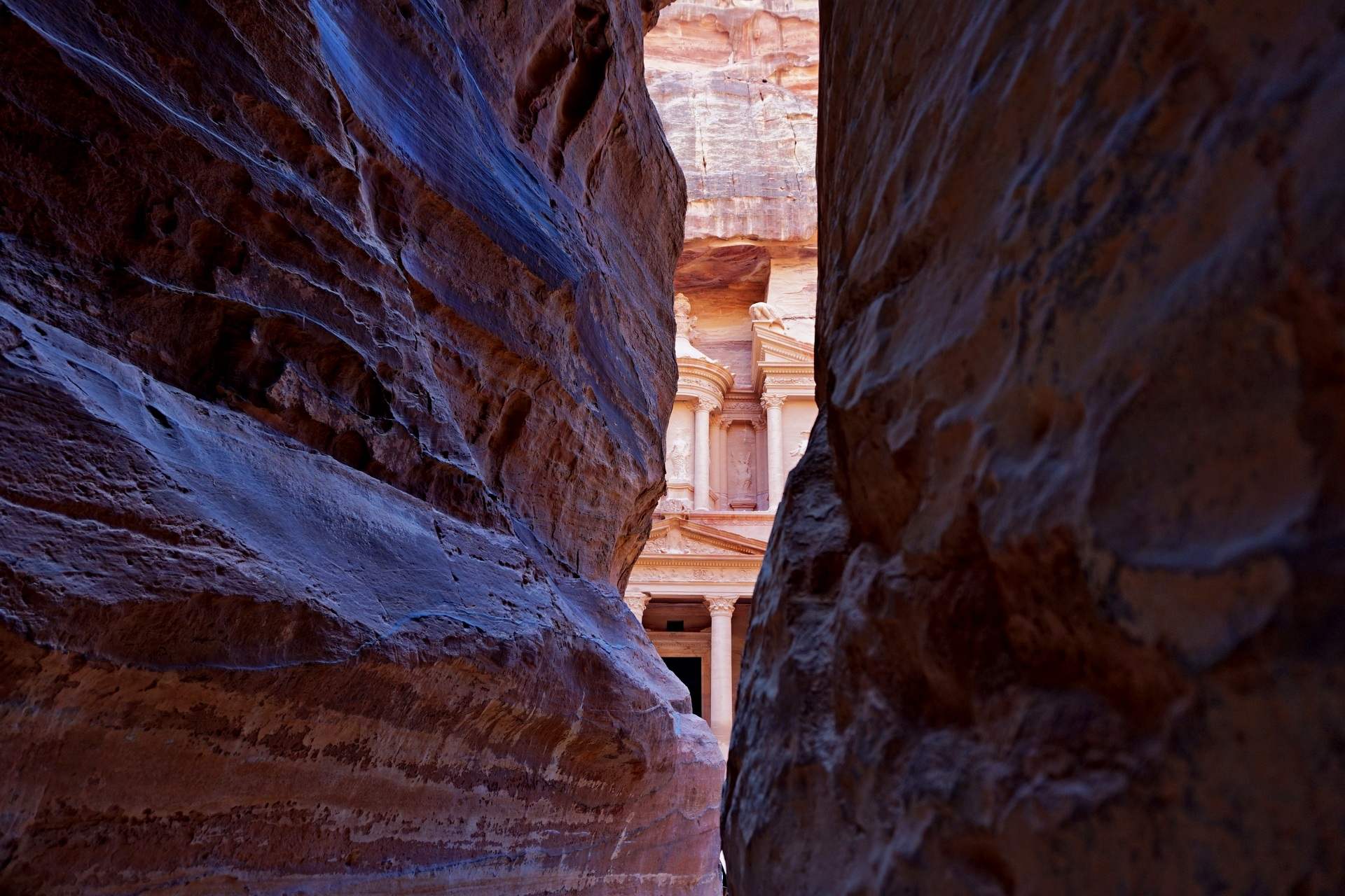 The iconic Treasury (Al-Khazneh) in Petra, Jordan, framed by towering sandstone cliffs; A scenic view of the Siq, the narrow canyon leading to Petra’s ancient ruins; A traveler on horseback exploring Petra’s archaeological wonders; The Monastery (Ad-Deir) standing tall against Petra’s rugged mountain landscape; Camel resting in front of the Treasury, a symbol of Petra’s desert heritage; Panoramic view of Petra’s Royal Tombs carved into red sandstone cliffs; Sunset over Petra, casting a golden glow on the ancient rock-cut structures; Local Bedouins in traditional attire guiding tourists through Petra’s hidden trails; Aerial view of Petra, showcasing the vastness of the ancient Nabatean city; A traveler marveling at the intricate carvings of Petra’s ancient facades.