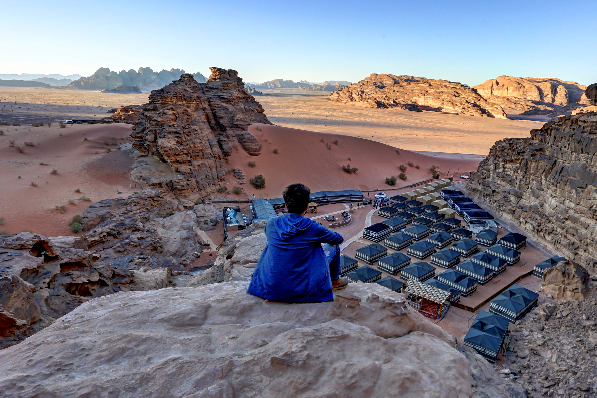 Wadi Rum desert landscape with red sand dunes; Jeep safari adventure in Wadi Rum with Bedouin guide; Panoramic view of sandstone mountains in Wadi Rum; Tourists exploring rock formations in Wadi Rum; Camel ride experience in Wadi Rum desert; Traditional Bedouin tent camp in Wadi Rum at sunset; Bedouin hospitality with tea in Wadi Rum; Starry night sky over Wadi Rum desert camp; Sunrise view over Wadi Rum mountains; Bedouin preparing dinner in desert camp